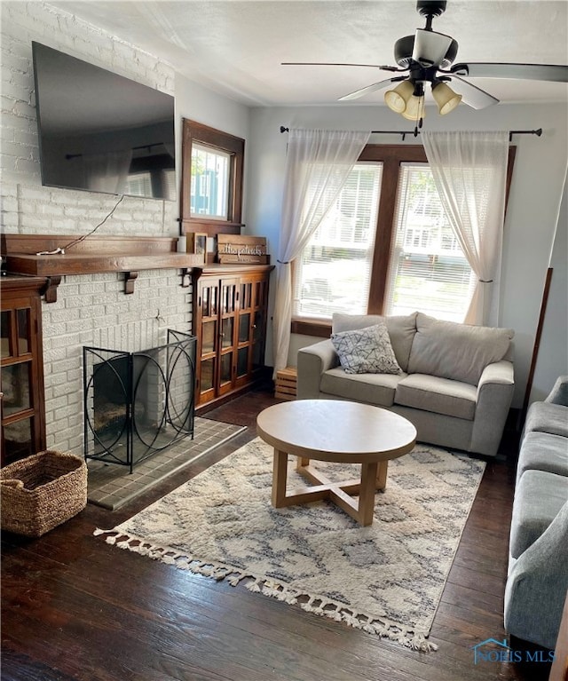 living room featuring a fireplace, dark hardwood / wood-style floors, and ceiling fan