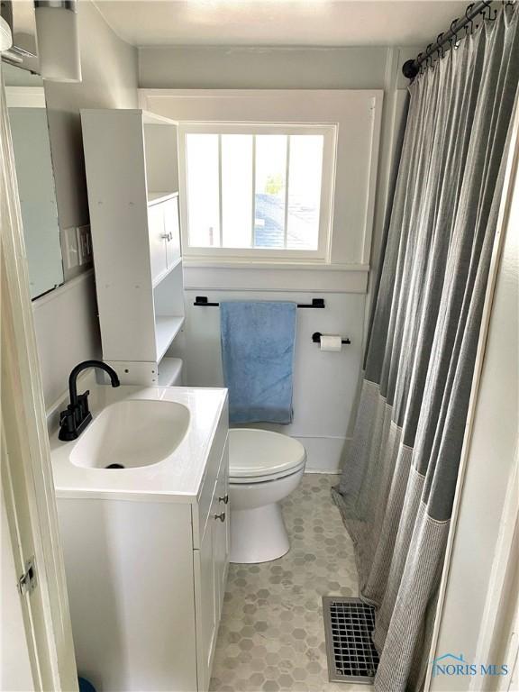 bathroom featuring vanity, tile patterned flooring, and toilet