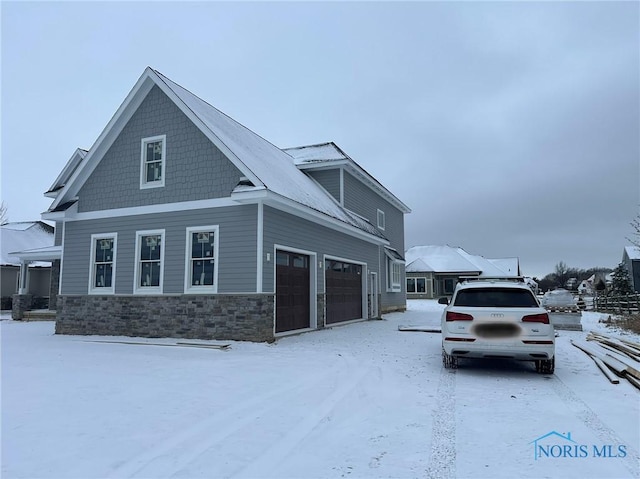 view of snowy exterior with a garage