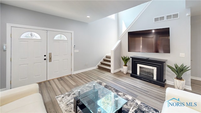 foyer entrance featuring a fireplace and light wood-type flooring