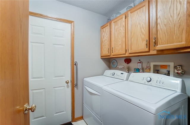 laundry area featuring washer and clothes dryer and cabinets