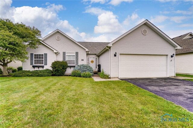 ranch-style house with a garage and a front lawn