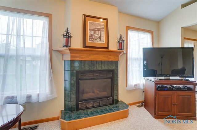 carpeted living room with a tiled fireplace