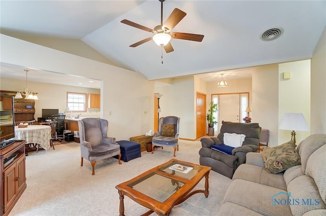 carpeted living room featuring ceiling fan with notable chandelier and lofted ceiling