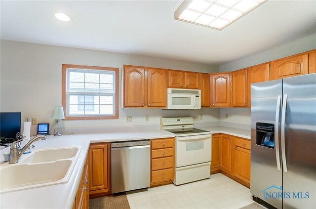 kitchen with sink, light tile patterned floors, and stainless steel appliances