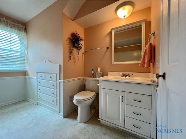 bathroom featuring vanity, toilet, and vaulted ceiling