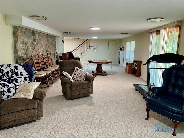 carpeted living room featuring a stone fireplace