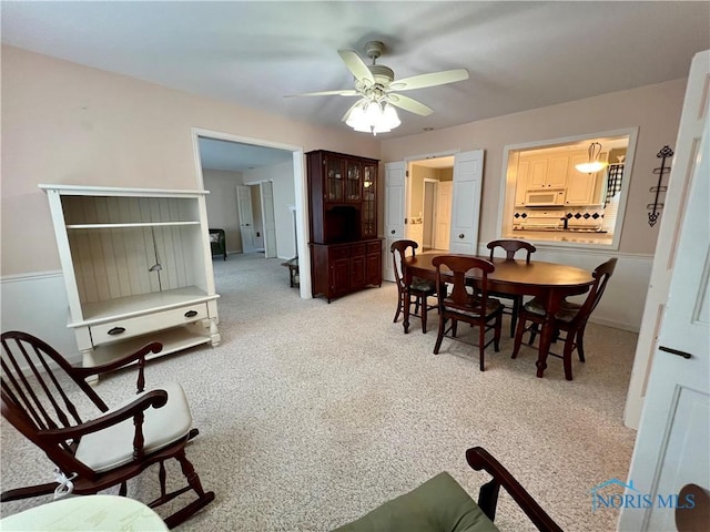 carpeted dining space featuring ceiling fan