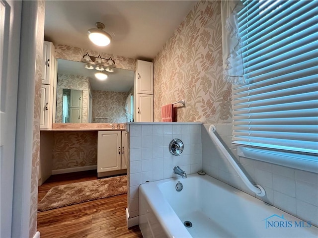 bathroom featuring vanity, hardwood / wood-style floors, and a tub