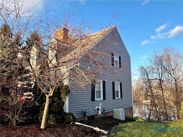 view of side of home with a yard and central air condition unit