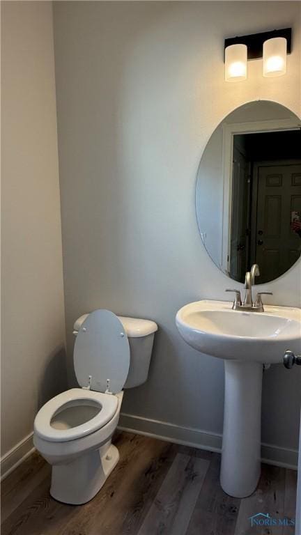 bathroom featuring hardwood / wood-style flooring and toilet