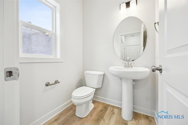 bathroom featuring wood-type flooring and toilet