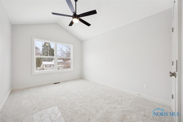 empty room featuring carpet floors, ceiling fan, and vaulted ceiling