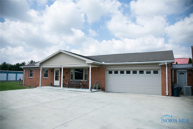 single story home with cooling unit, covered porch, and a garage