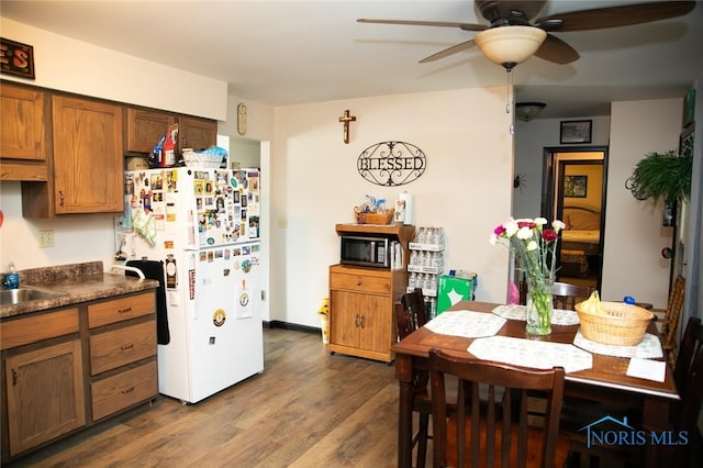 kitchen featuring ceiling fan, white refrigerator, and dark hardwood / wood-style flooring