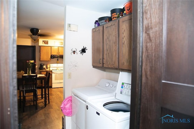 washroom featuring cabinets, washing machine and dryer, and wood-type flooring