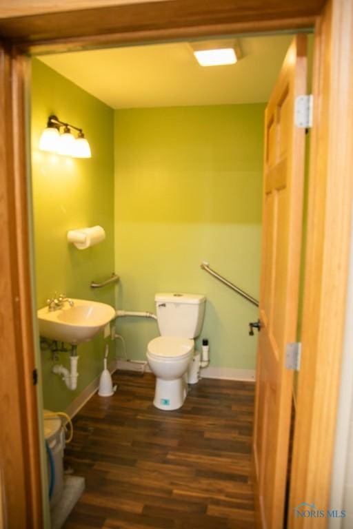 bathroom featuring toilet, wood-type flooring, and sink