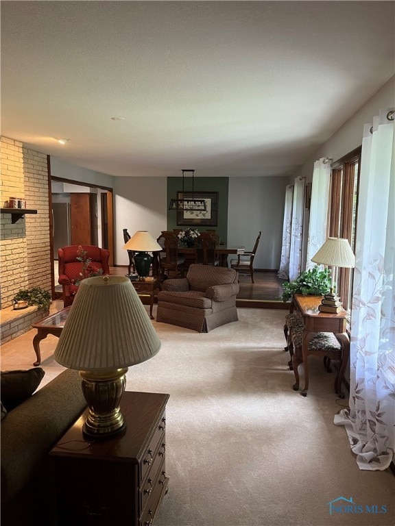 living room with brick wall, a fireplace, and carpet floors