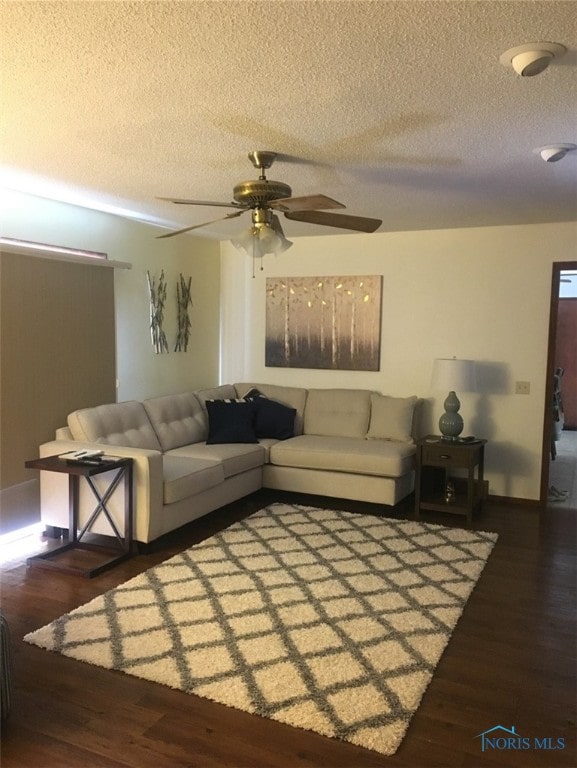 living room with ceiling fan, hardwood / wood-style flooring, and a textured ceiling