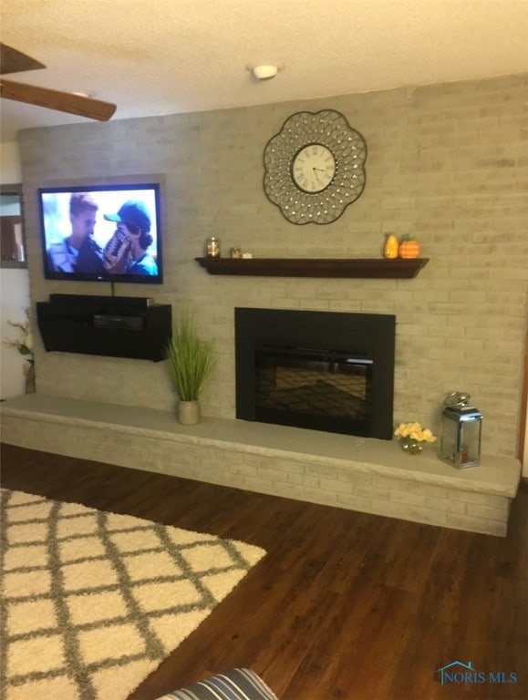 living room with hardwood / wood-style floors, a textured ceiling, and a fireplace