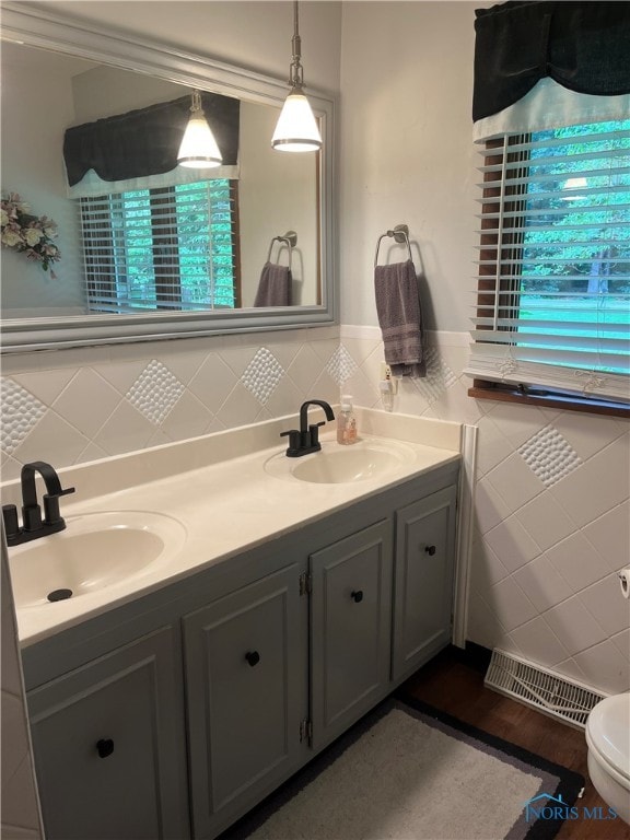 bathroom featuring vanity, toilet, hardwood / wood-style floors, and tile walls