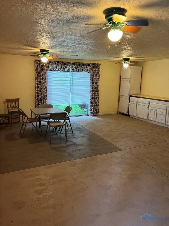 dining room featuring concrete flooring and a textured ceiling