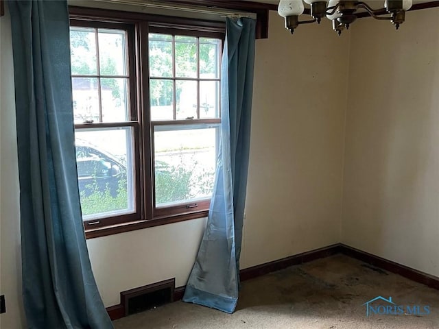 spare room featuring an inviting chandelier