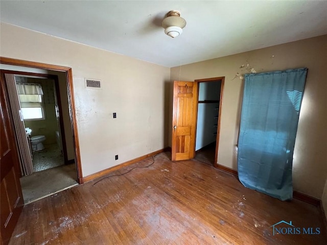 unfurnished bedroom with wood-type flooring and a closet