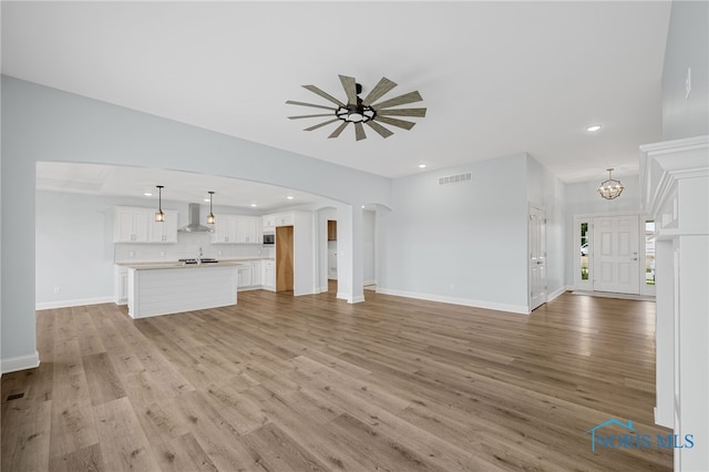 unfurnished living room with light hardwood / wood-style flooring and ceiling fan