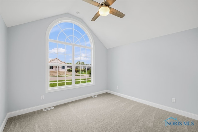 empty room featuring ceiling fan, carpet floors, and vaulted ceiling