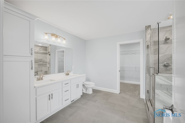 bathroom featuring vanity, toilet, and a shower with door