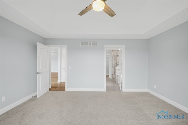 unfurnished bedroom with light carpet, ceiling fan, and ensuite bath