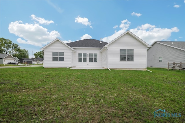 rear view of house with a lawn and a patio