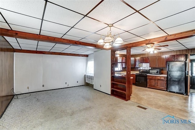 kitchen featuring ceiling fan with notable chandelier, hanging light fixtures, black appliances, and light carpet