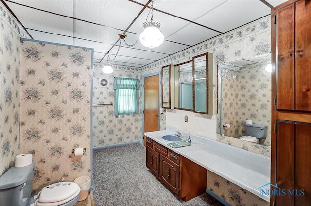 bathroom with toilet, a drop ceiling, and vanity