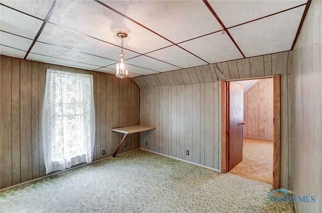 additional living space featuring vaulted ceiling and carpet flooring