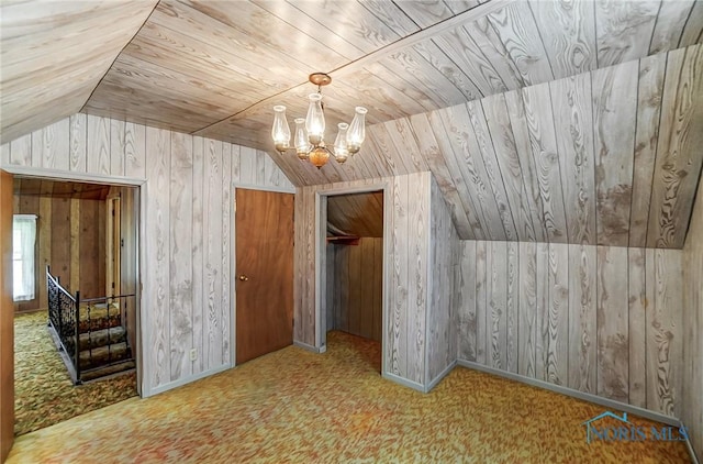 additional living space featuring light carpet, wood walls, wooden ceiling, a notable chandelier, and vaulted ceiling