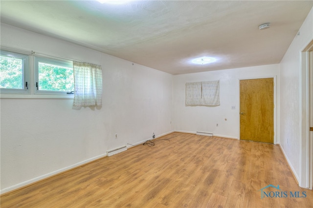 unfurnished room with light hardwood / wood-style flooring and a baseboard radiator