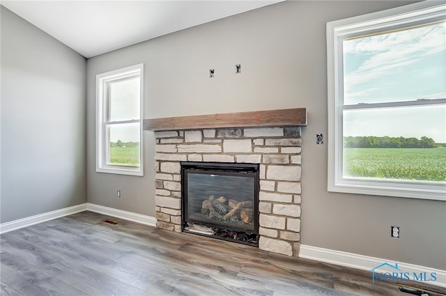 unfurnished living room featuring a fireplace, vaulted ceiling, and wood-type flooring