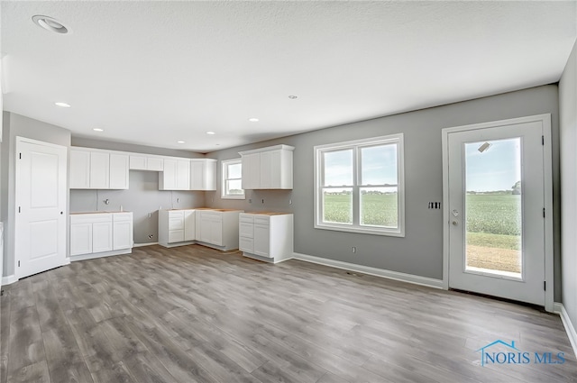 interior space featuring light wood-type flooring and white cabinetry