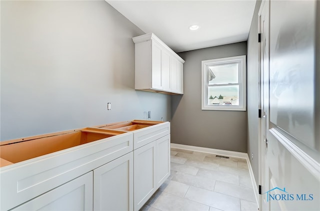 laundry area with light tile patterned floors and sink