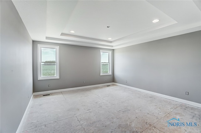 empty room featuring a raised ceiling