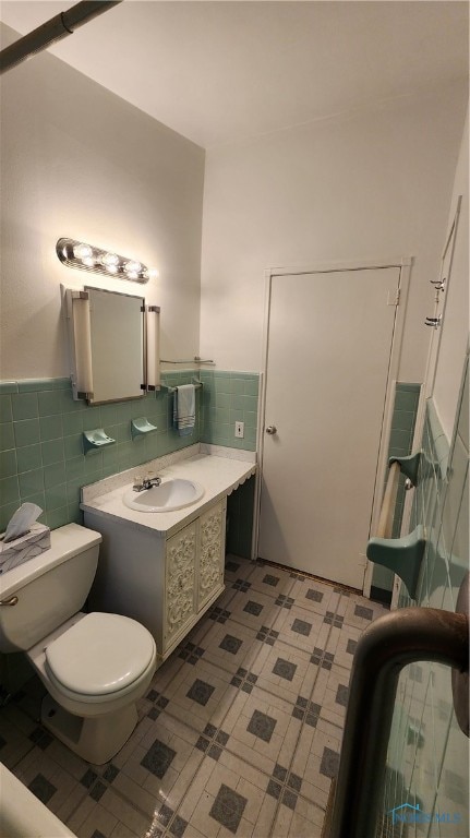 bathroom featuring tile walls, toilet, and vanity