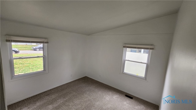 carpeted spare room with lofted ceiling