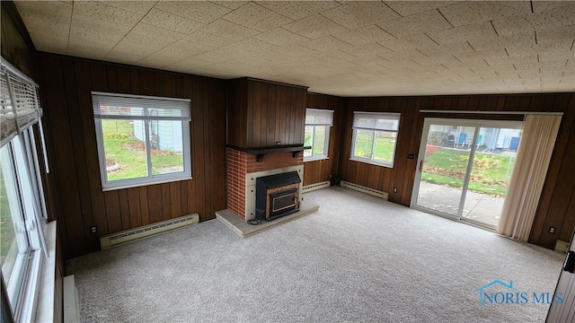 unfurnished living room featuring baseboard heating and a wealth of natural light