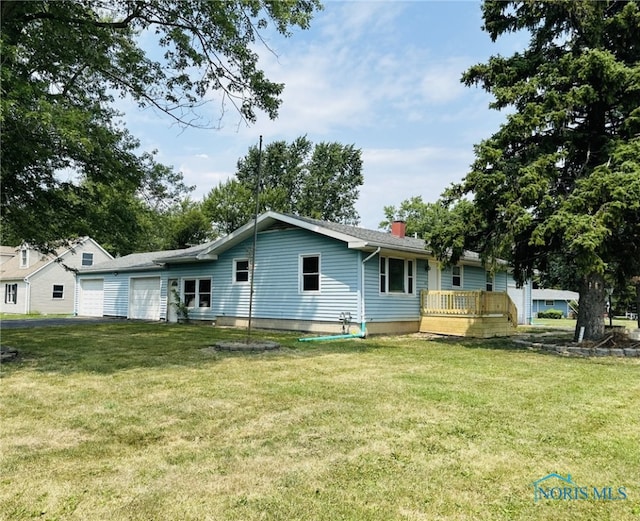 back of house with a garage and a yard