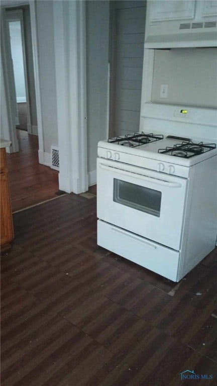 kitchen featuring white cabinets, white gas range oven, and dark hardwood / wood-style flooring