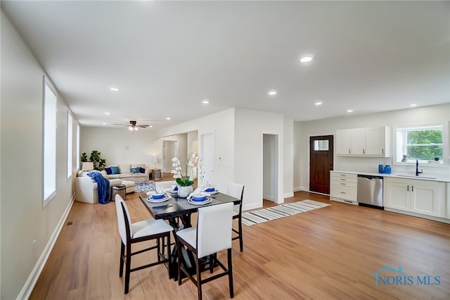 dining space with light hardwood / wood-style flooring, sink, and ceiling fan