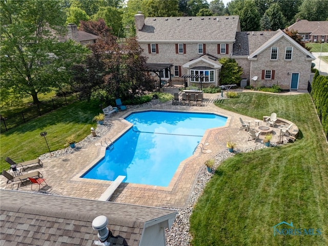 view of pool with a patio, a diving board, and a yard