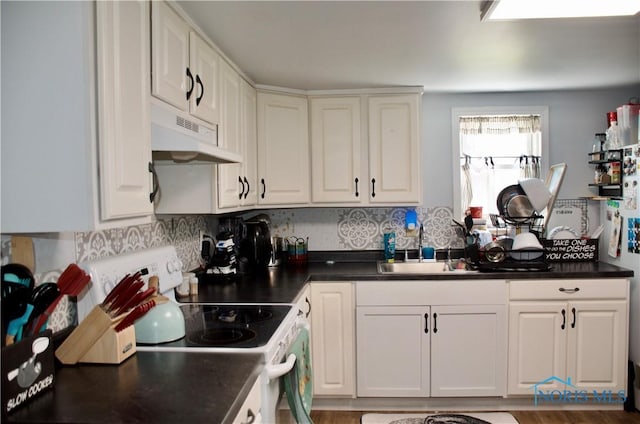 kitchen with white electric stove, sink, white cabinets, and decorative backsplash